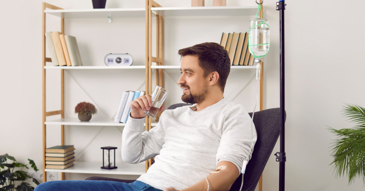 Man receiving IV therapy at home while drinking water in Fountain Valley, CA